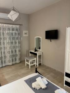 a bedroom with a bed and a mirror and a tv at Victoria's Blue studios in Siviri