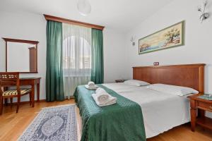 a bedroom with a bed and a desk and a window at Villa Armin in Rovinj