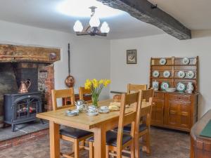 a dining room with a wooden table and a fireplace at Upper Ffinnant in Aber-Brân