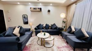 a living room with blue couches and a table at Elysium Tower - LMY Executive Hotel Serviced Apartments Facing Centaurus Mall Islamabad in Islamabad