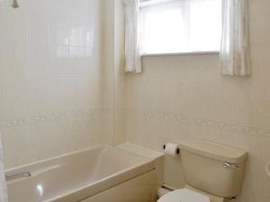 baño con aseo, bañera y ventana en Westward Ho - Uk44492, en Hope-Cove