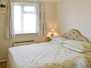 Un dormitorio con una cama grande con ventana. en Westward Ho - Uk44492, en Hope-Cove