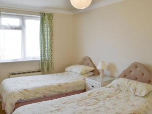 Un dormitorio con dos camas y una ventana en Westward Ho - Uk44492, en Hope-Cove
