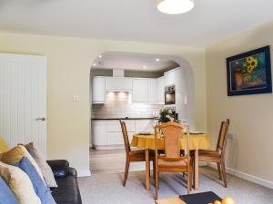 a kitchen and dining room with a table and chairs at Between The Forest And The Sea in New Milton