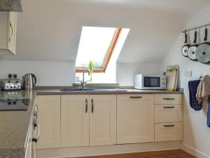 a kitchen with a sink and a window at The Boathouse in Little Haven +10 photos