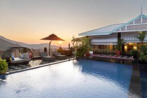a pool at a hotel with a view of the mountains at Mayfair Manor Jungpana in Darjeeling