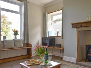 a living room with a fireplace and a tv at Slant End Cottage in Golcar