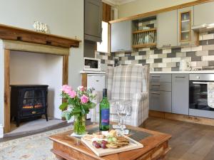 a living room with a table with a vase of flowers at Slant End Cottage in Golcar