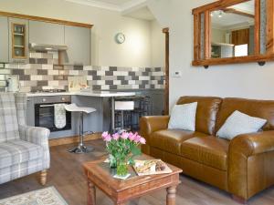 a living room with a couch and a table at Slant End Cottage in Golcar