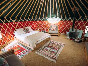 1 habitación con 1 cama y 1 silla en una yurta en Moss Yurt - Uk47888, en Keilour