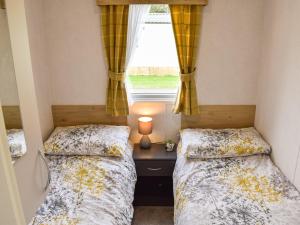 two beds in a small room with a window at Brimham Retreat - Uk37641 in Knaresborough