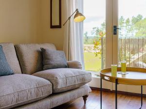 a living room with a couch and a table and a window at Turnip Cottage in Newsham