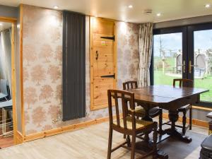 a dining room with a wooden table and chairs at Pineville in Dover