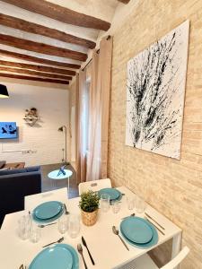 a dining room with a white table with blue plates at Vive Zaragoza XV in Zaragoza