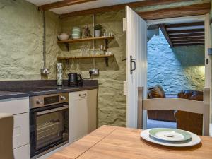 a kitchen with a table and a counter top at Little Sitch Barn - Uk39602 in Matlock Bank