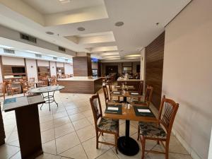 a dining room with tables and chairs in a restaurant at Hotel Estanpla Moema Ibirapuera com garagem piscina 1004 in Sao Paulo