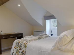 Un dormitorio con una cama y un escritorio y una ventana. en The Coach House Halifax, en Halifax