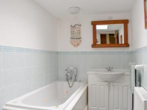a bathroom with a tub and a sink at Awd Tuts in Whitby