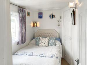 a bedroom with a white bed with blue pillows at Driftwood in Mundesley