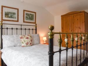 a bedroom with a bed and a wooden cabinet at Awd Tuts in Whitby