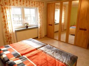 ein Schlafzimmer mit einem Bett und einem großen Spiegel in der Unterkunft Ferienwohnung Hutterer in Bad Griesbach