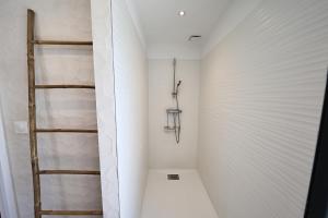 Un pequeño baño con ducha con paredes blancas. en Casa di Lilla - Escapade dans une maison de charme, en San-Gavino-di-Carbini 26 fotos más
