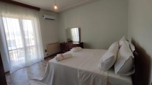 a bedroom with a white bed with white sheets and pillows at Terry's House in Fondi