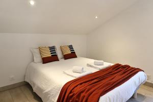 Una cama blanca con dos almohadas encima. en Casa di Lilla - Escapade dans une maison de charme, en San-Gavino-di-Carbini