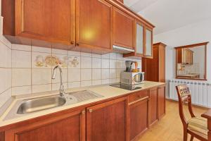 a kitchen with wooden cabinets and a sink at Villa Armin in Rovinj +31 photos