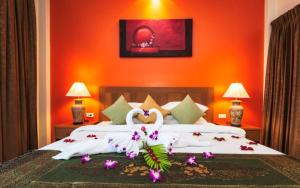 a bedroom with two swans laying on a bed at Katanoi Resort in Kata Beach