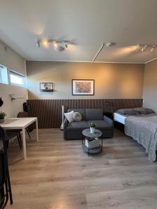 a bedroom with a bed and a couch and a table at BergOne in Ytri-Njarðvík