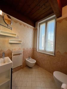 a bathroom with a sink and a toilet and a window at Domus Cerchio 19 - Affitti Brevi Italia in Ravenna