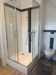 a shower stall in a bathroom with a toilet at Dachgeschosswohnung Benther Berg, Contactless Check-in, free parking, Vollsaniert und Renoviert 2025 in Ronnenberg +15 photos