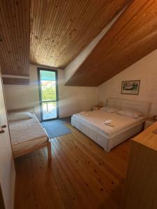a bedroom with a bed and a wooden ceiling at Apartments Renato in Vrboska