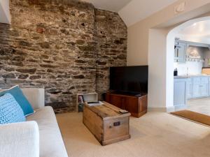 Una sala de estar con un sofá y un televisor. en Aloft, en Salcombe