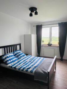 una camera da letto con un letto con un piumone blu e bianco di Apartament Aquatower a Reda