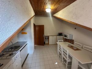 a kitchen with a table and some chairs in a room at Apartments Renato in Vrboska