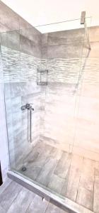 una doccia con una porta in vetro in un bagno di Athitos cozy Studios ad Áfitos