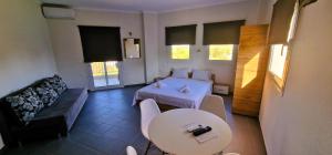 una stanza con un letto, un tavolo e un divano di Athitos cozy Studios ad Áfitos