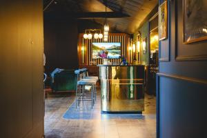a room with a bar with stools in it at The Originals Boutique, Hôtel Le Londres, Saumur in Saumur