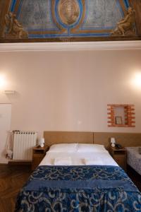 a bedroom with a bed with a blue blanket on it at Family Hotel Balbi in Genova +40 photos