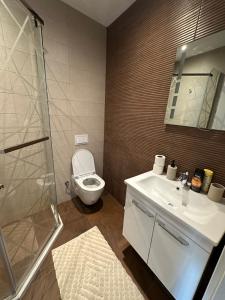 a bathroom with a toilet and a sink and a shower at Pika Apartment in Pristina +5 photos