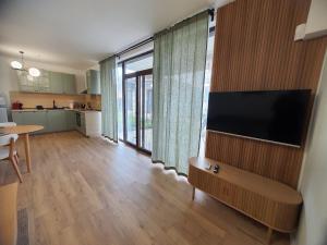 a living room with a flat screen tv on a wall at Вила Фамилия - Villa Family in Lozenets