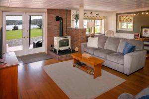a living room with a couch and a tv at Green Acre on Lamoka Lake in Hammondsport