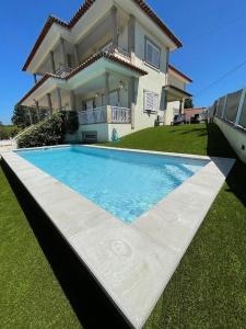 una casa con piscina delante de una casa en Lux House, en Ferreira