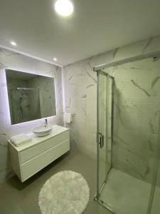 a white bathroom with a sink and a shower at Lux House in Ferreira +31 photos