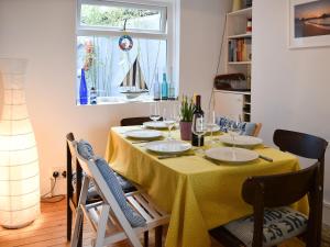 a dining room with a table with a yellow table cloth at Blue Cottage in Broadstairs +12 photos