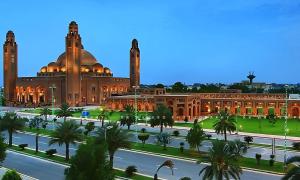 a large building with palm trees in front of it at LMY Stays Bahria Prestige Apartments Lahore in Lahore