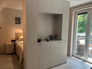 a bedroom with white cabinets and a bed and a window at Za Murem in Sandomierz