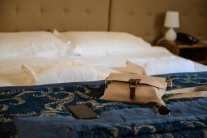 a purse and a cell phone sitting on a bed at Family Hotel Balbi in Genoa